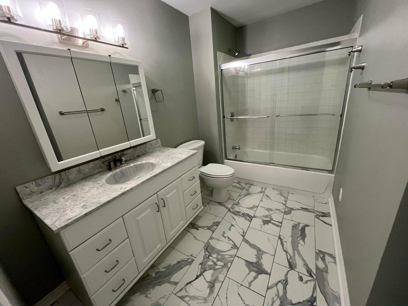 1415 Ebeling Drive Plainview, TX 79072 - Photo 28 of 46 a bathroom with a granite countertop sink toilet and shower