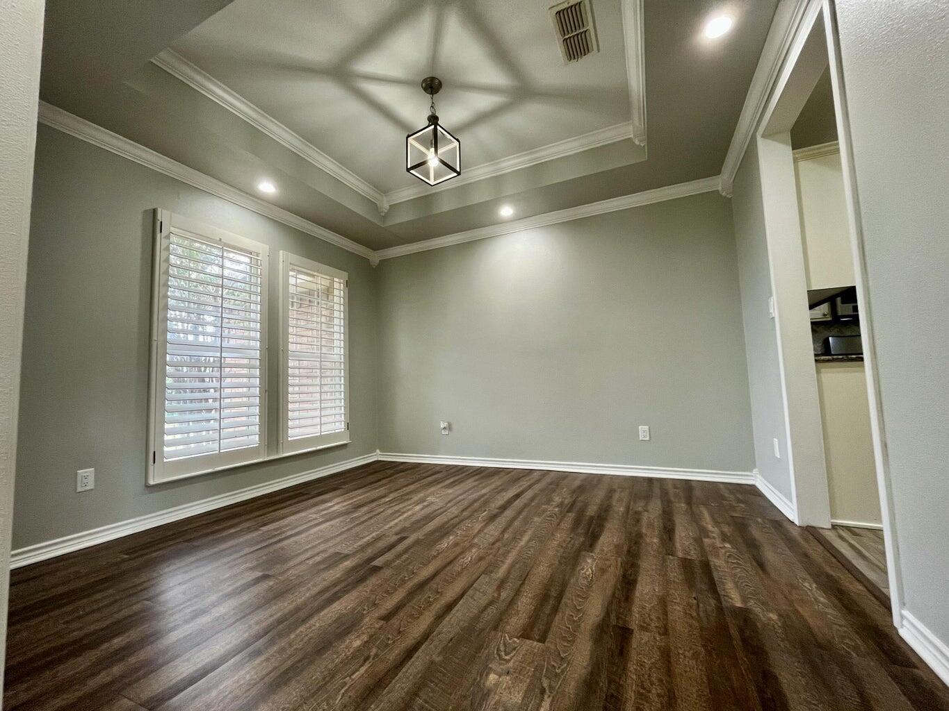 1415 Ebeling Drive Plainview, TX 79072 - Photo 6 of 46 an empty room with wooden floor and windows