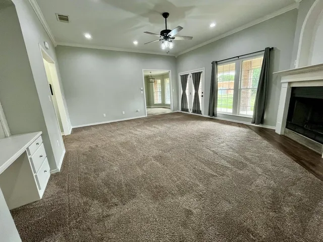 a view of an empty room with a fireplace and a window