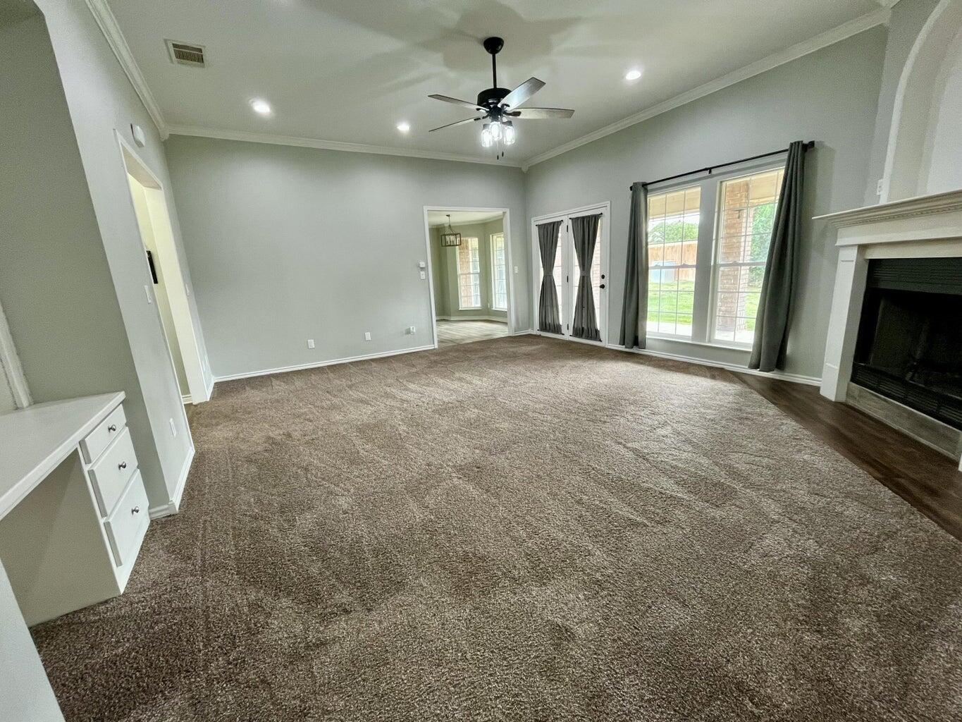 1415 Ebeling Drive Plainview, TX 79072 - Photo 7 of 46 a view of an empty room with a fireplace and a window