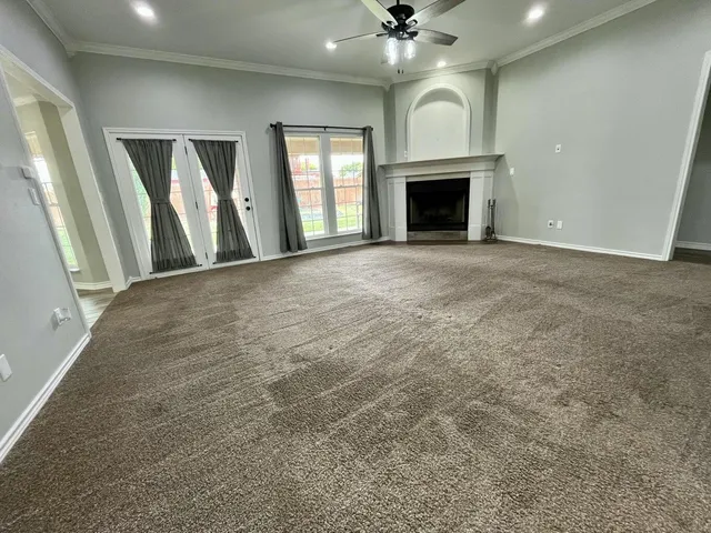 an empty room with fireplace and windows