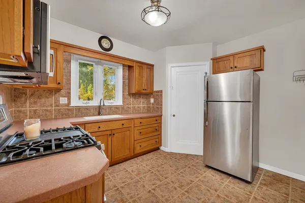 a kitchen with stainless steel appliances a stove a refrigerator and a window