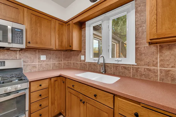 a kitchen with granite countertop a sink a stove and cabinets