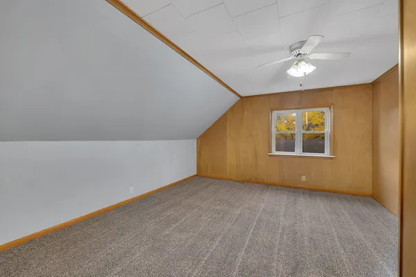 an empty room with a window and a ceiling fan