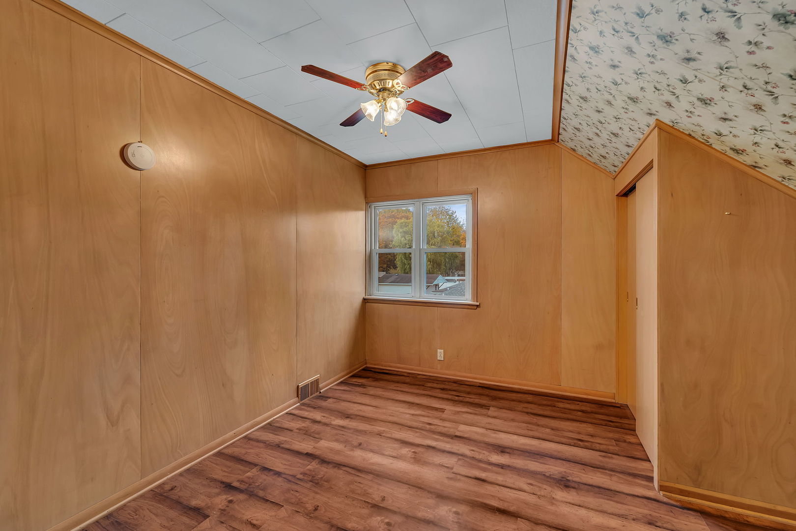 405 West Bluff Street Streator, IL 61364 - Photo 22 of 31 a view of an empty room with wooden floor and a ceiling fan