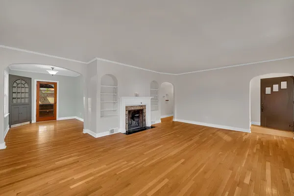 a view of empty room with wooden floor and fireplace