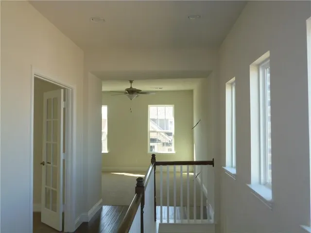 a view of a hallway with windows and chandelier