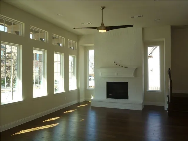 a living room with a fireplace and wooden floor