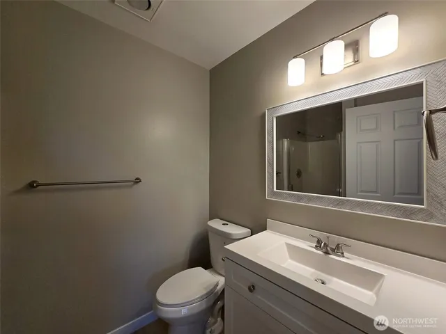 a bathroom with a sink a toilet and a mirror