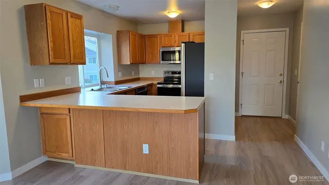 a kitchen with stainless steel appliances a refrigerator and a stove top oven