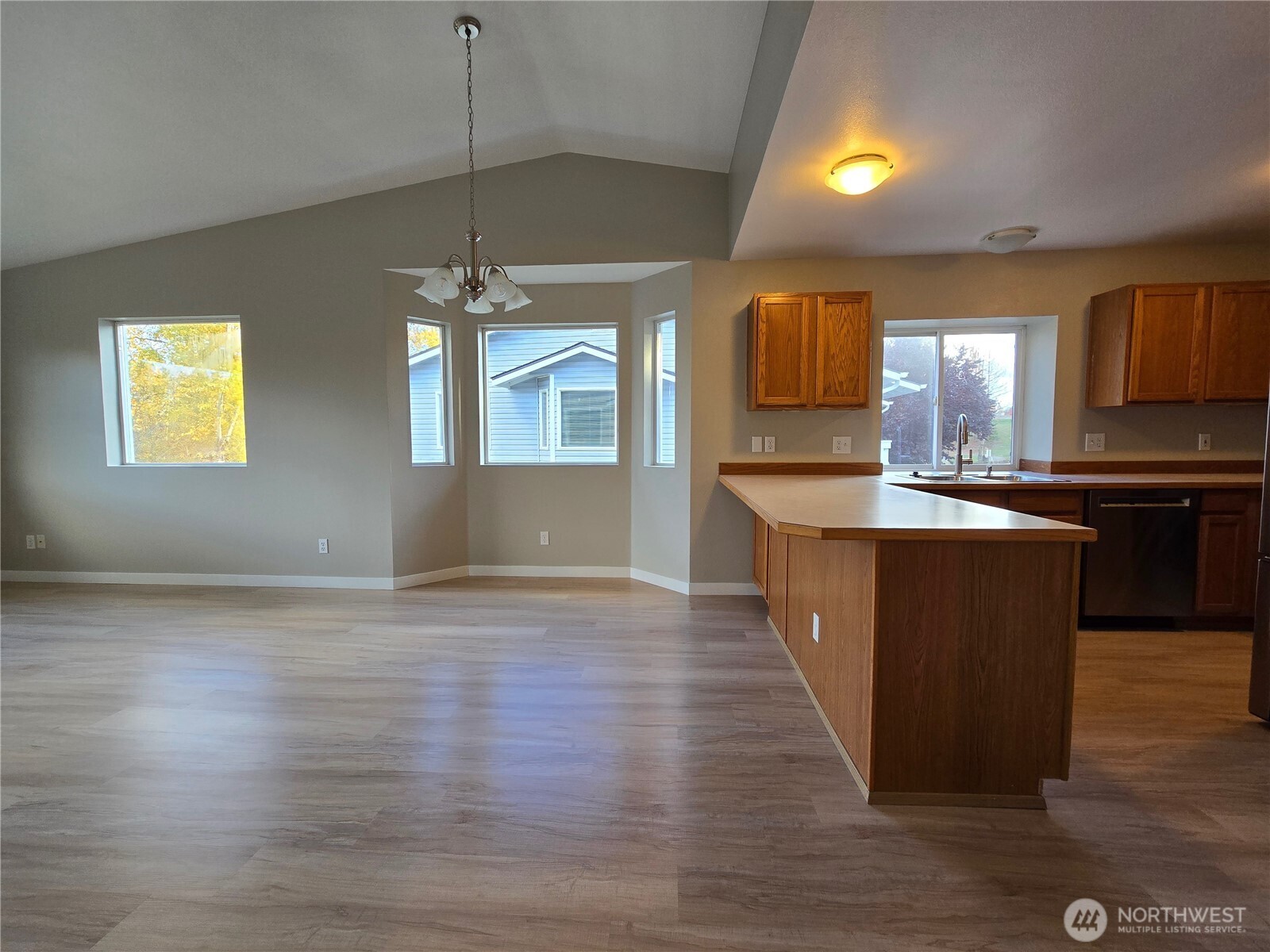 12432 Southeast 272nd Place, Unit B202 Kent, WA 98030 - Photo 6 of 25 a kitchen with kitchen island granite countertop a sink cabinets and wooden floor