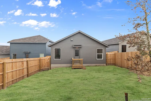 a backyard of a house with table and chairs