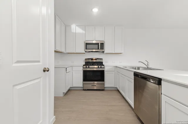a kitchen with sink cabinets and a refrigerator