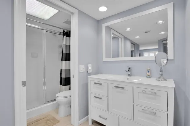 a spacious bathroom with a toilet sink double vanity and mirror
