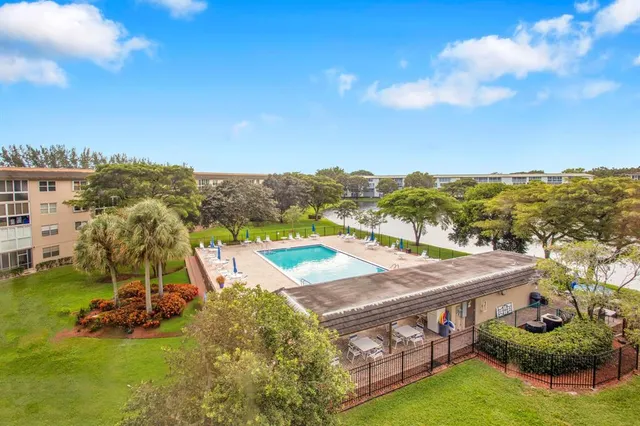 an aerial view of a residential houses with outdoor space and swimming pool