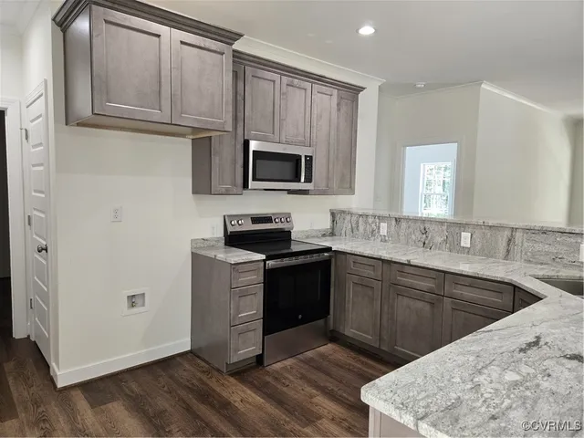 a kitchen with stainless steel appliances granite countertop a sink stove and microwave