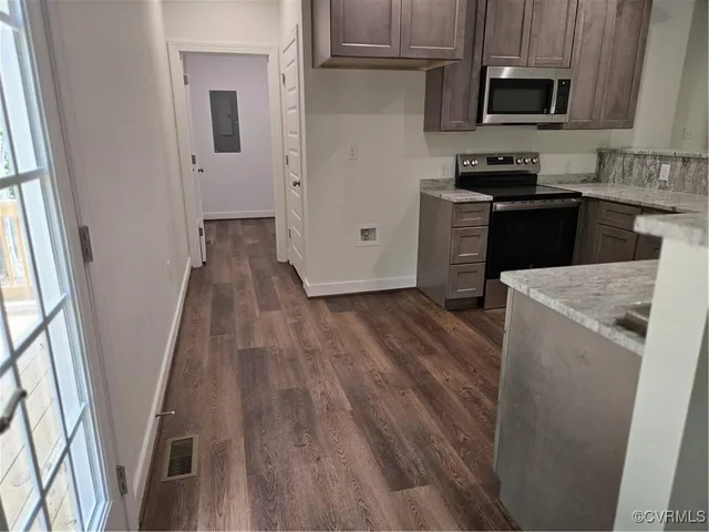 a kitchen with wooden floors and black appliances