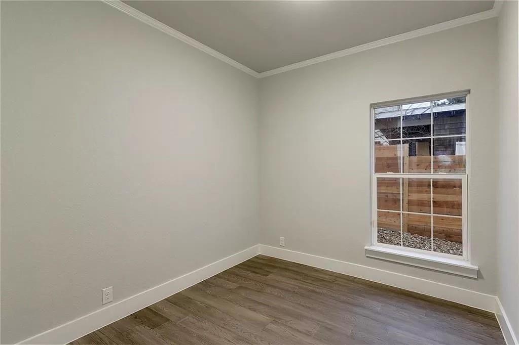 1217 Eleanor Street Austin, TX 78721 - Photo 12 of 17 Empty room featuring dark wood-style floors and ornamental molding