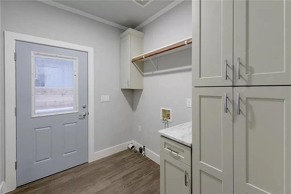 1217 Eleanor Street Austin, TX 78721 - Photo 17 of 17 Laundry area featuring ornamental molding, hookup for a washing machine, cabinet space, and dark wood-type flooring