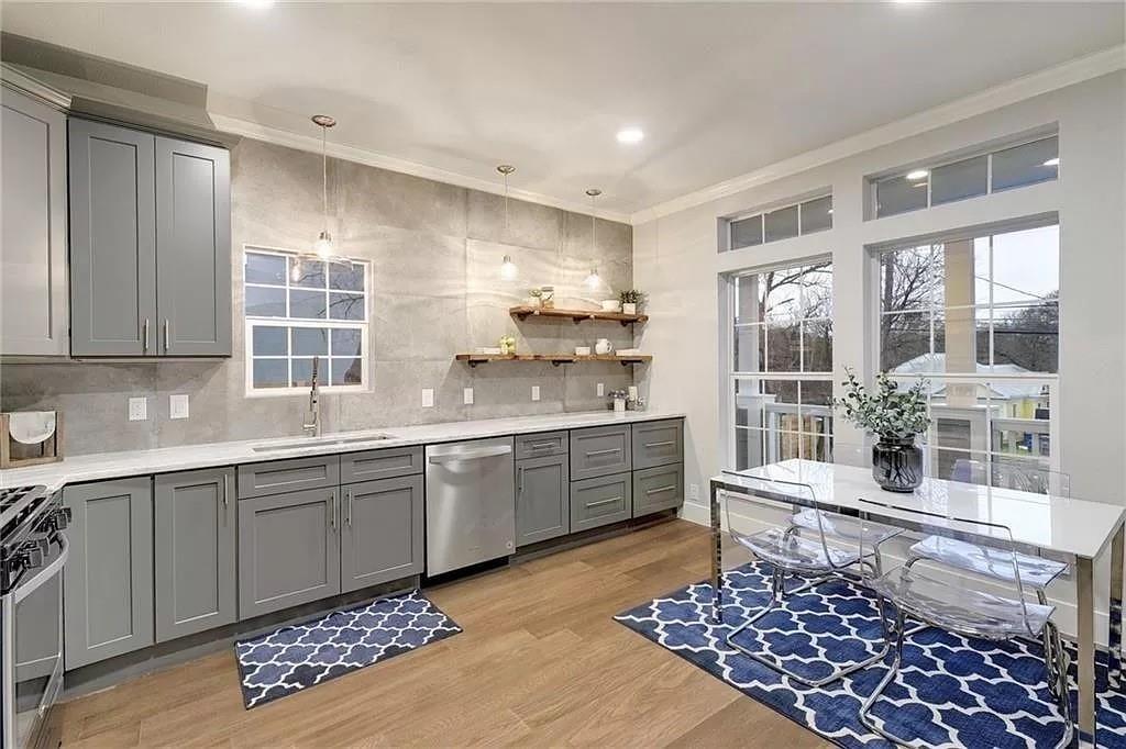 1217 Eleanor Street Austin, TX 78721 - Photo 6 of 17 Kitchen with gray cabinetry, ornamental molding, decorative backsplash, light wood-style flooring, and light stone counters
