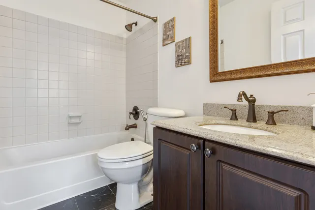 a bathroom with a granite countertop sink toilet and shower