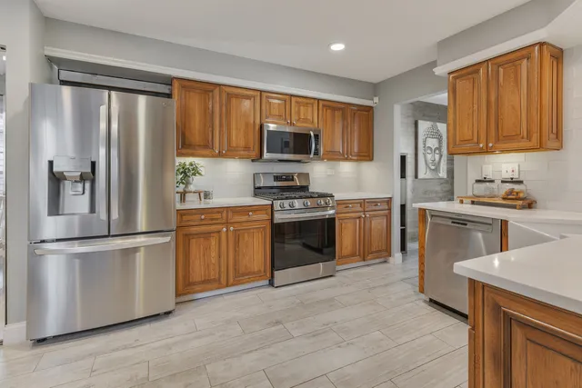a kitchen with cabinets stainless steel appliances and a window