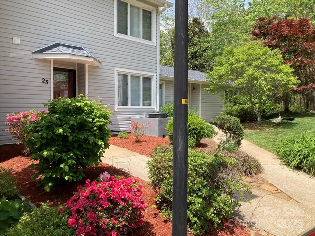 a front view of a house with a yard and fountain