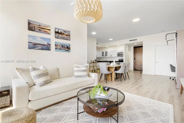 a living room with furniture and a dining table with kitchen view