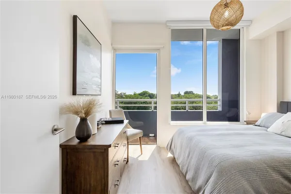 a bedroom with a bed and large windows