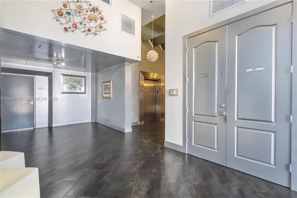 a view of a hallway with wooden floor and chandelier