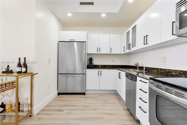 a kitchen with white cabinets and white appliances