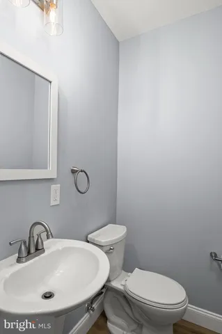 a bathroom with a toilet a sink and mirror
