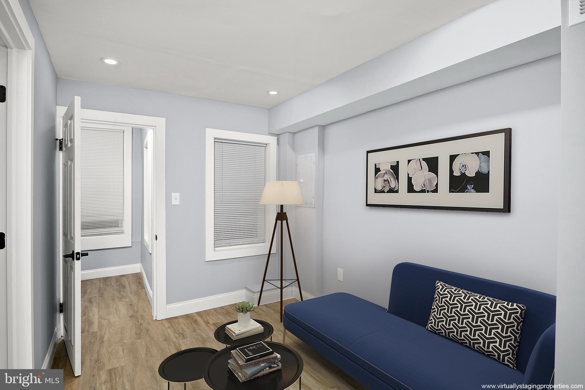 2112 Eastern Avenue Baltimore, MD 21231 - Photo 23 of 43 a living room with furniture a rug and a wooden floor