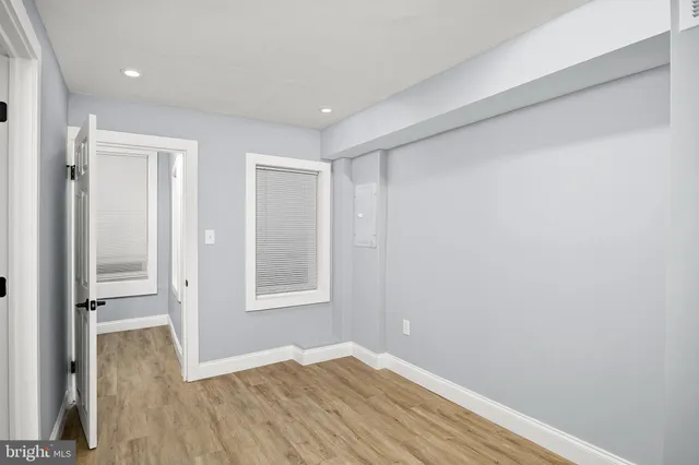 a view of empty room with wooden floor and entryway