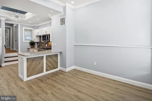 a view of kitchen with stainless steel appliances cabinets and wooden floor