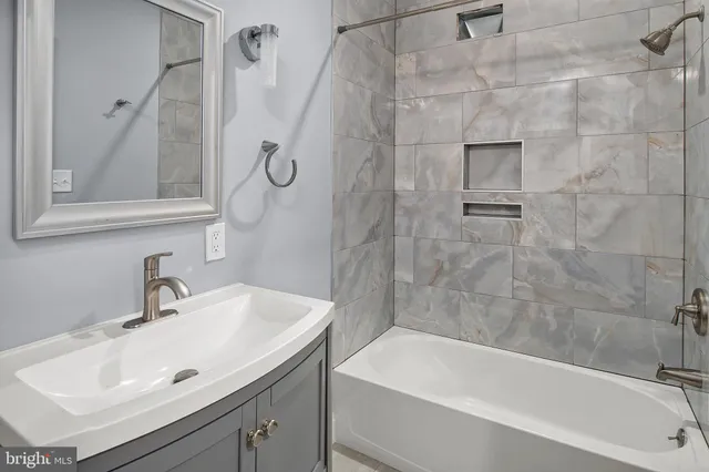 a bathroom with a sink a mirror and a bathtub