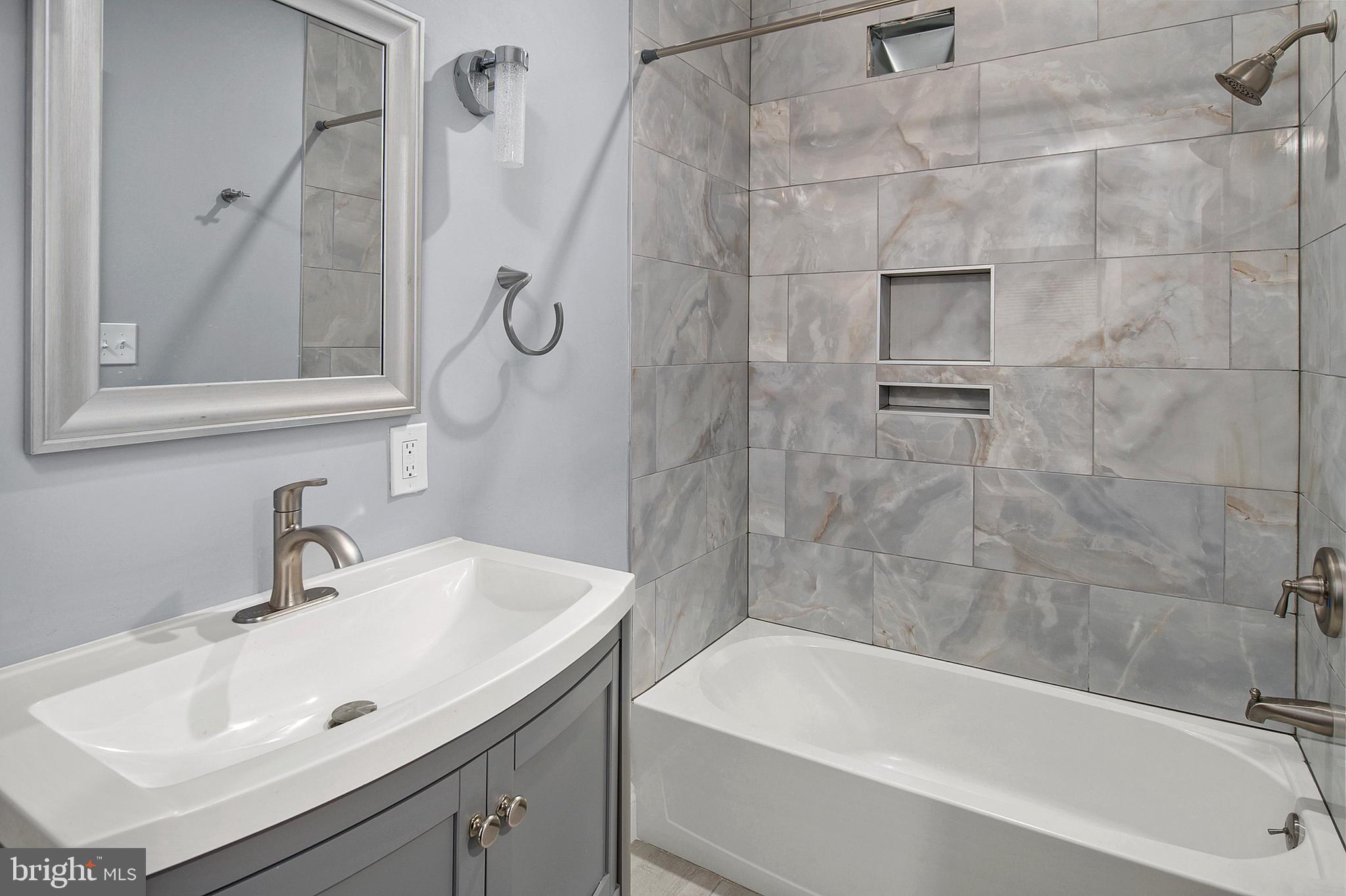 2112 Eastern Avenue Baltimore, MD 21231 - Photo 35 of 43 a bathroom with a sink a mirror and a bathtub