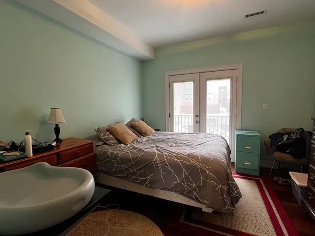 a bed sitting in a bedroom next to a window