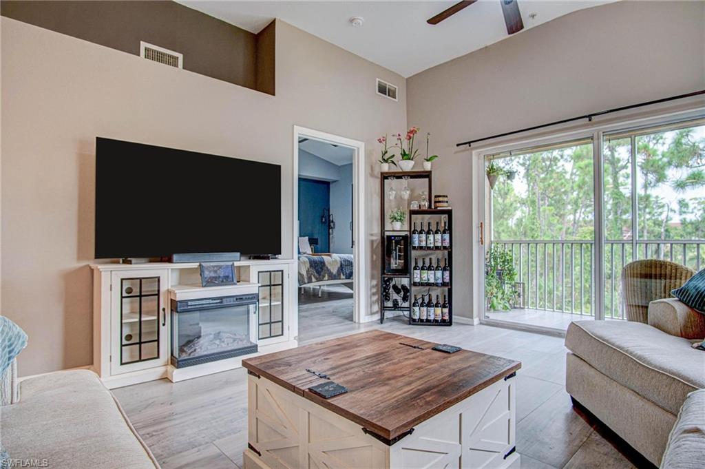 4450 Botanical Pl Circle, Unit 406 Naples, FL 34112 - Photo 1 of 16 a living room with furniture and a flat screen tv