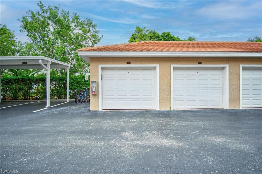 4450 Botanical Pl Circle, Unit 406 Naples, FL 34112 - Photo 16 of 16 a front view of a house with a yard and garage