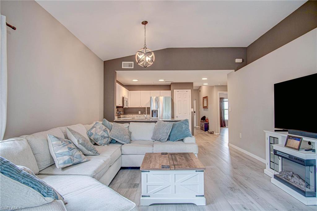 4450 Botanical Pl Circle, Unit 406 Naples, FL 34112 - Photo 4 of 16 a living room with furniture and a flat screen tv