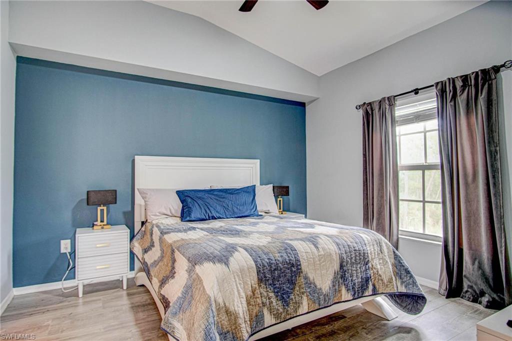 4450 Botanical Pl Circle, Unit 406 Naples, FL 34112 - Photo 7 of 16 a bedroom with a bed and wooden floor