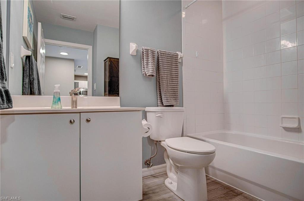 4450 Botanical Pl Circle, Unit 406 Naples, FL 34112 - Photo 8 of 16 a bathroom with a toilet sink and mirror