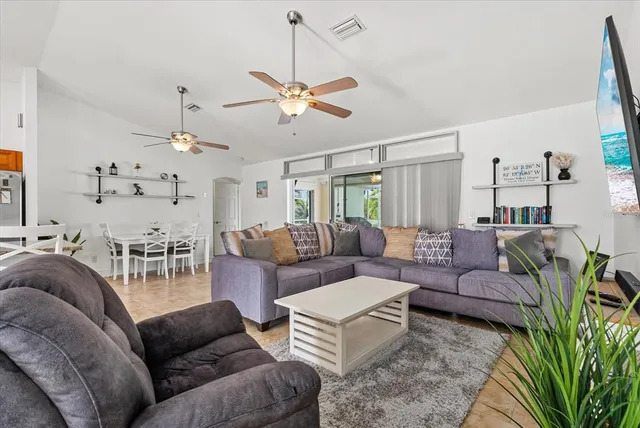 a living room with furniture kitchen view and a chandelier