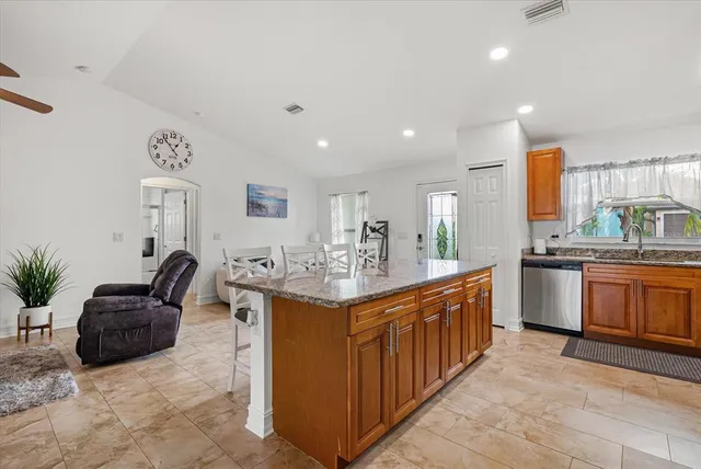a kitchen with stainless steel appliances kitchen island granite countertop a sink and cabinets