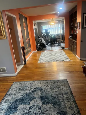 a view of empty room with wooden floor