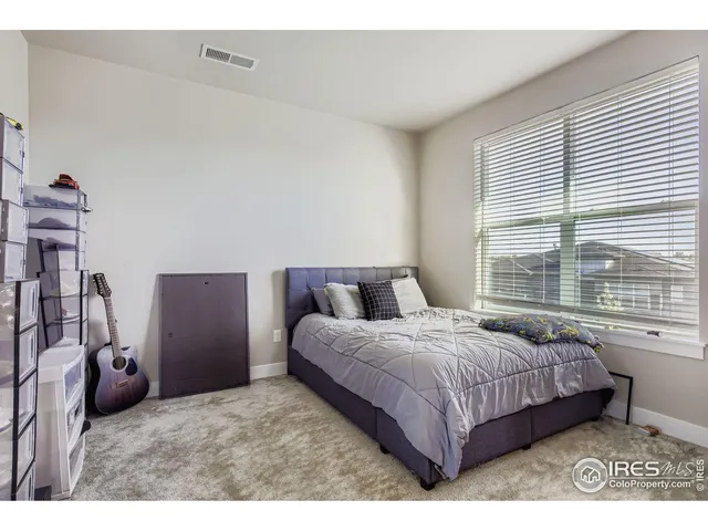 a bedroom with a bed next to a window