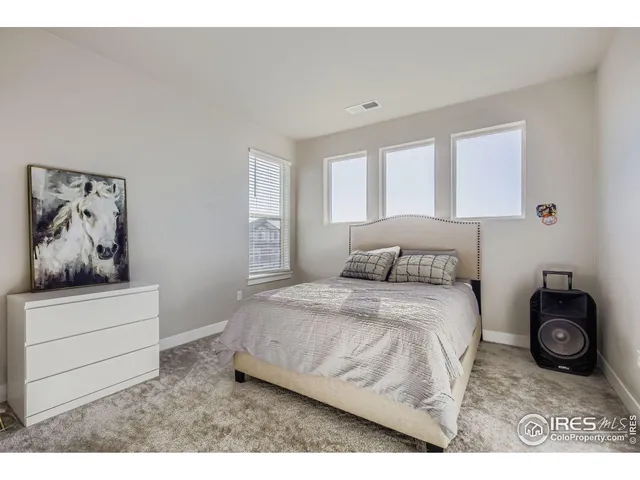 a bedroom with a bed and a painting on the wall