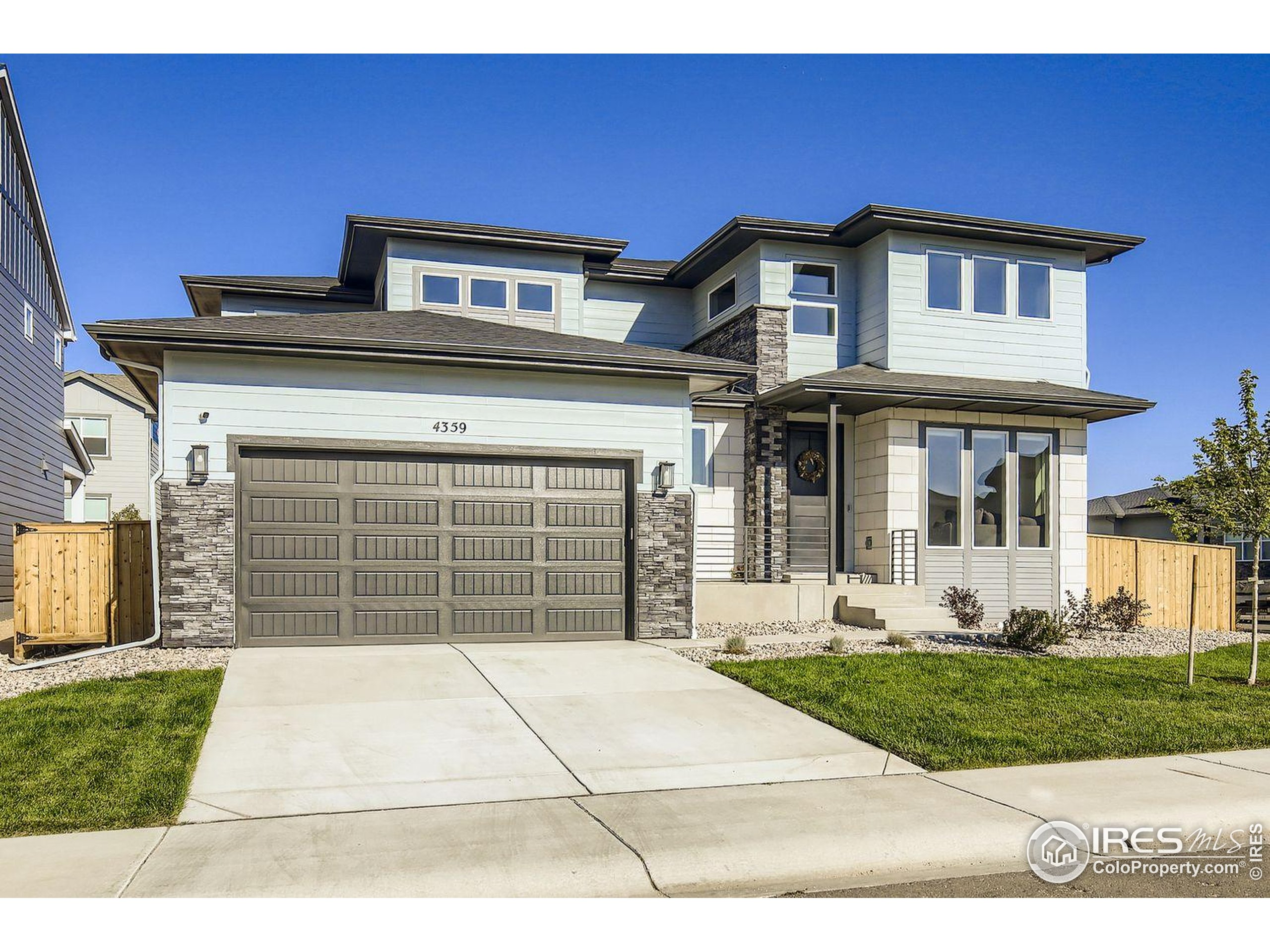 4359 Shivaree Street Timnath, CO 80547 - Photo 4 of 29 a front view of a house with a garden and garage