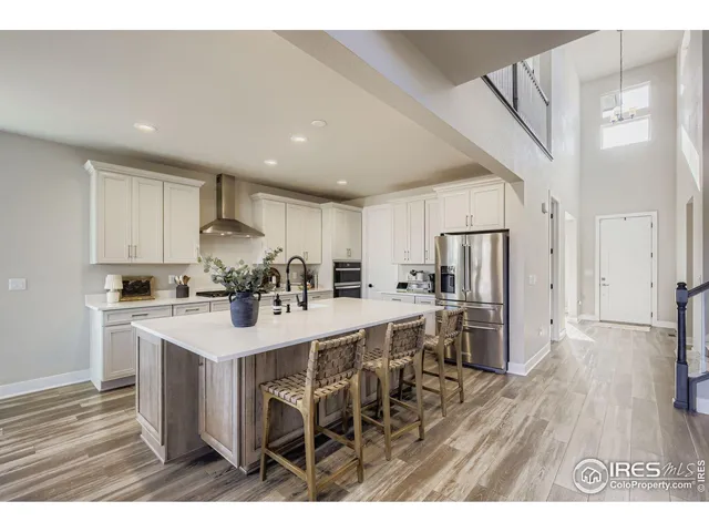 a kitchen with stainless steel appliances a table chairs refrigerator and wooden cabinets